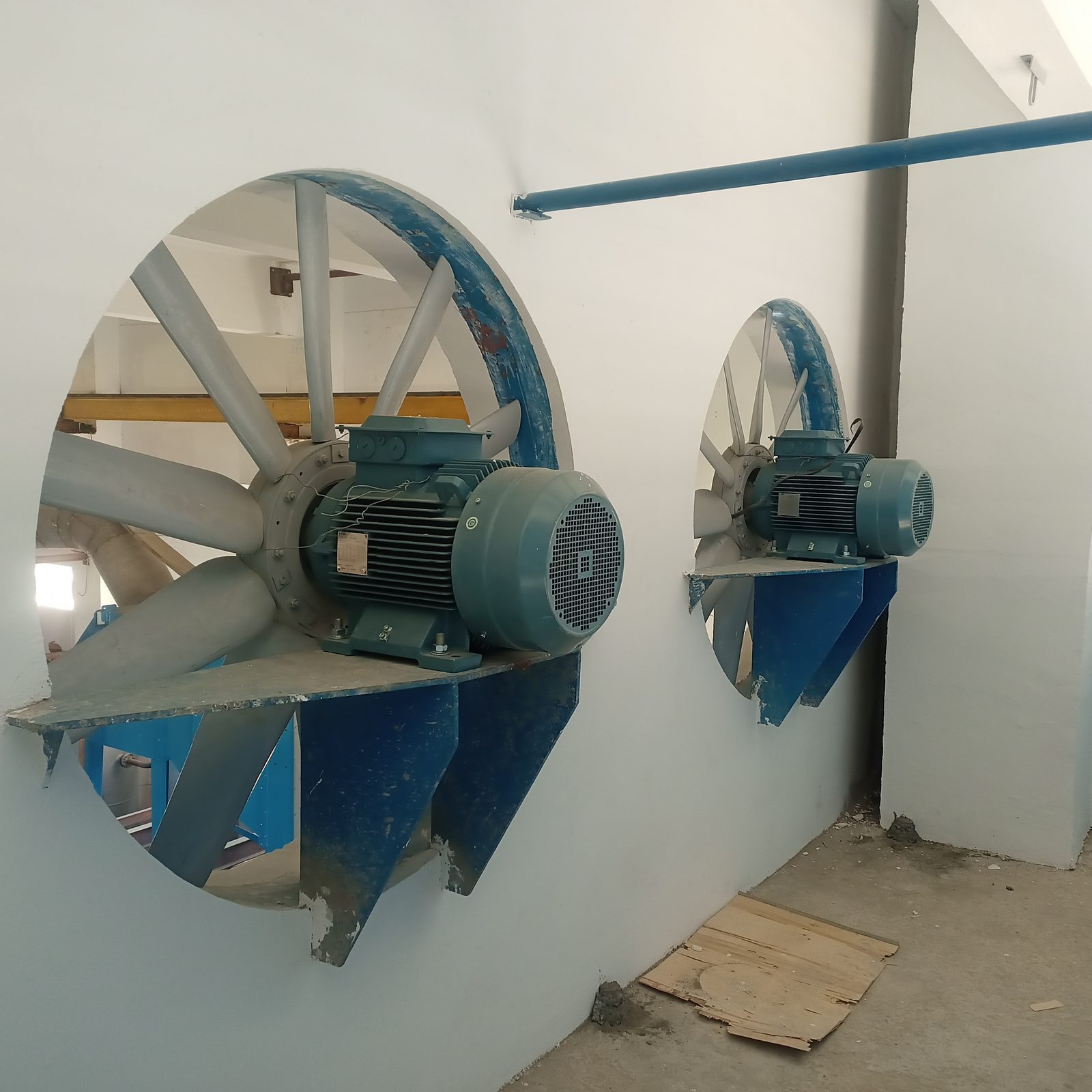 Axial exhaust fans being installed on a factory wall
